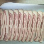 Bacon on parchment paper for Candied Bacon